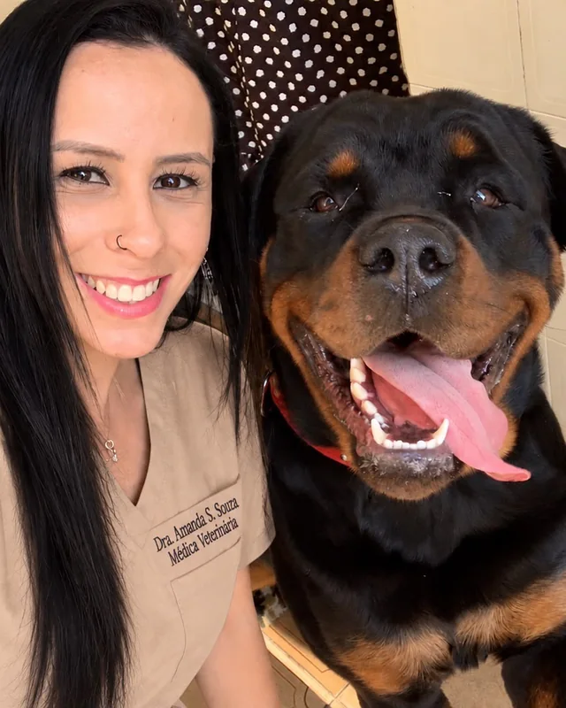 A Dra. Amanda sorrindo ao lado de um rottweiler