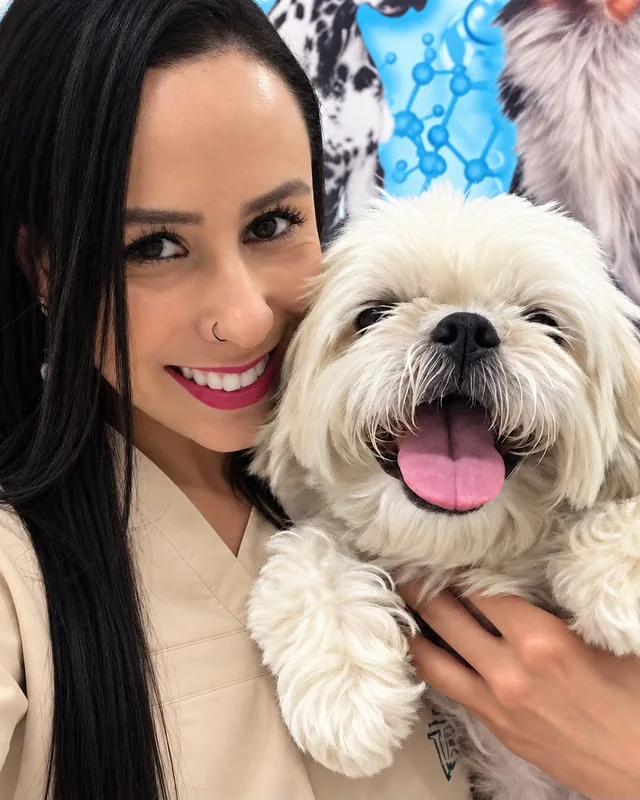 A Dra. Amanda abraçada a um cachorro de pelo branco